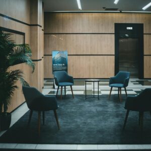 A stylish office lobby featuring chic chairs and a minimalistic design with a neutral tone.