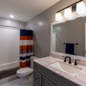 Bright and minimalist bathroom with a modern vanity and colorful shower curtain.
